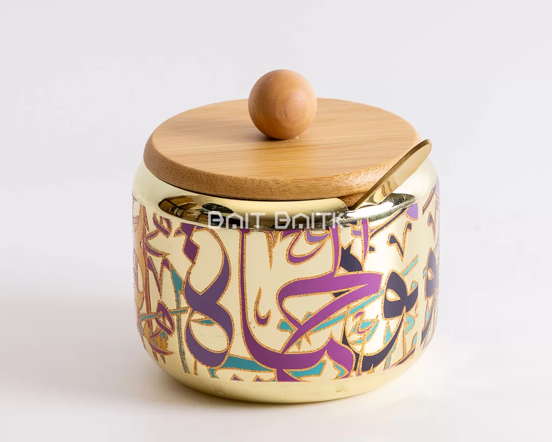 "Elegant gold sugar jar with Arabic calligraphy design, bamboo lid, and golden spoon — modern decorative container for sugar or condiments from Bait Baitk."