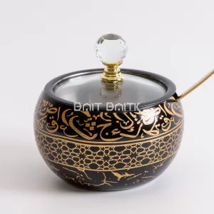 "Black sugar jar with golden Arabic calligraphy and geometric patterns, crystal knob, and gold spoon — luxurious Arabic-style serving jar from Bait Baitk."