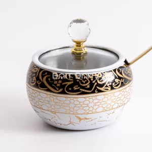 "White sugar jar with golden Arabic calligraphy and geometric design, crystal knob, and gold spoon — luxurious Arabic-style jar from Bait Baitk."